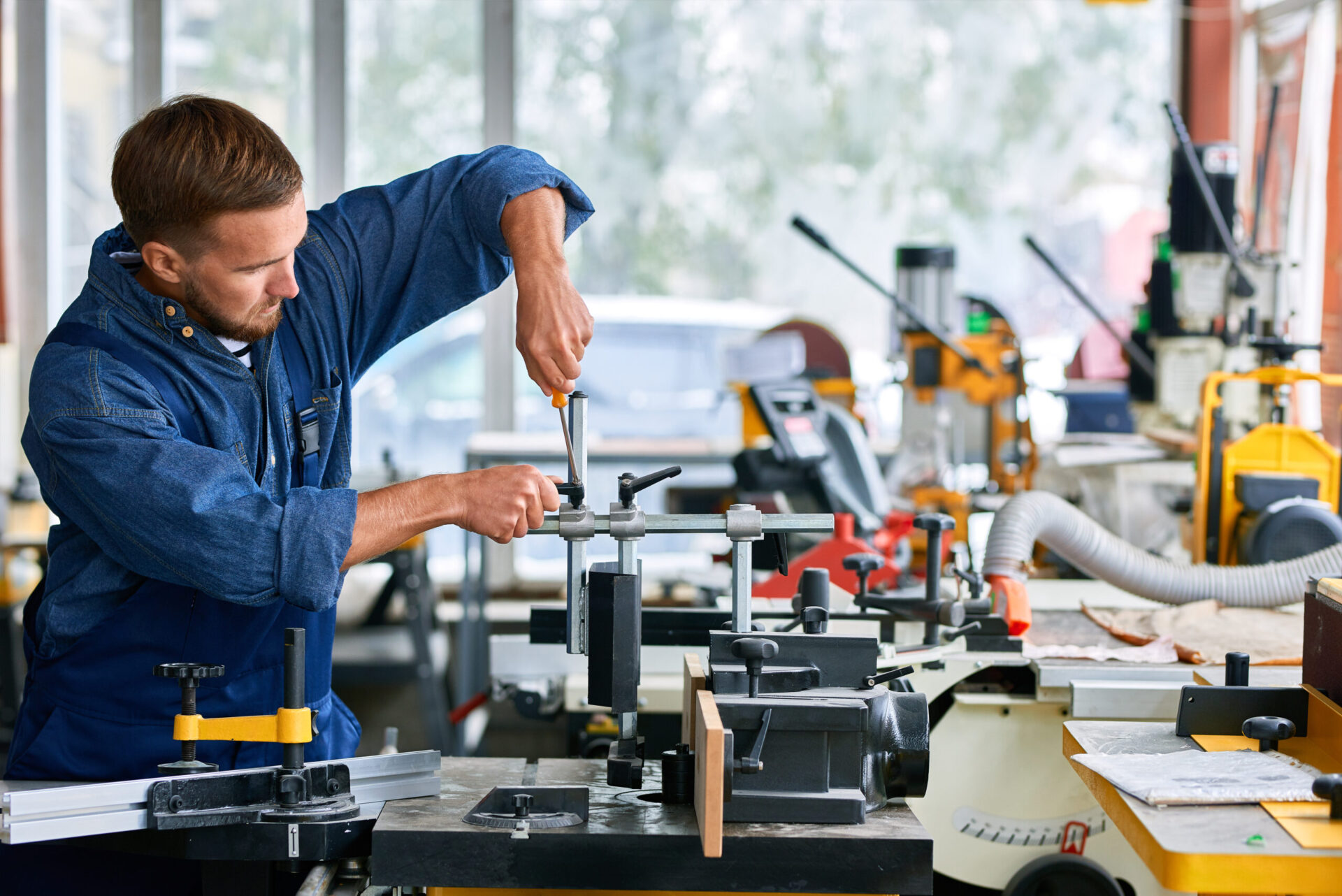 Side view portrait of young man working at modern factory repairing machine units in industrial workshop, copy space